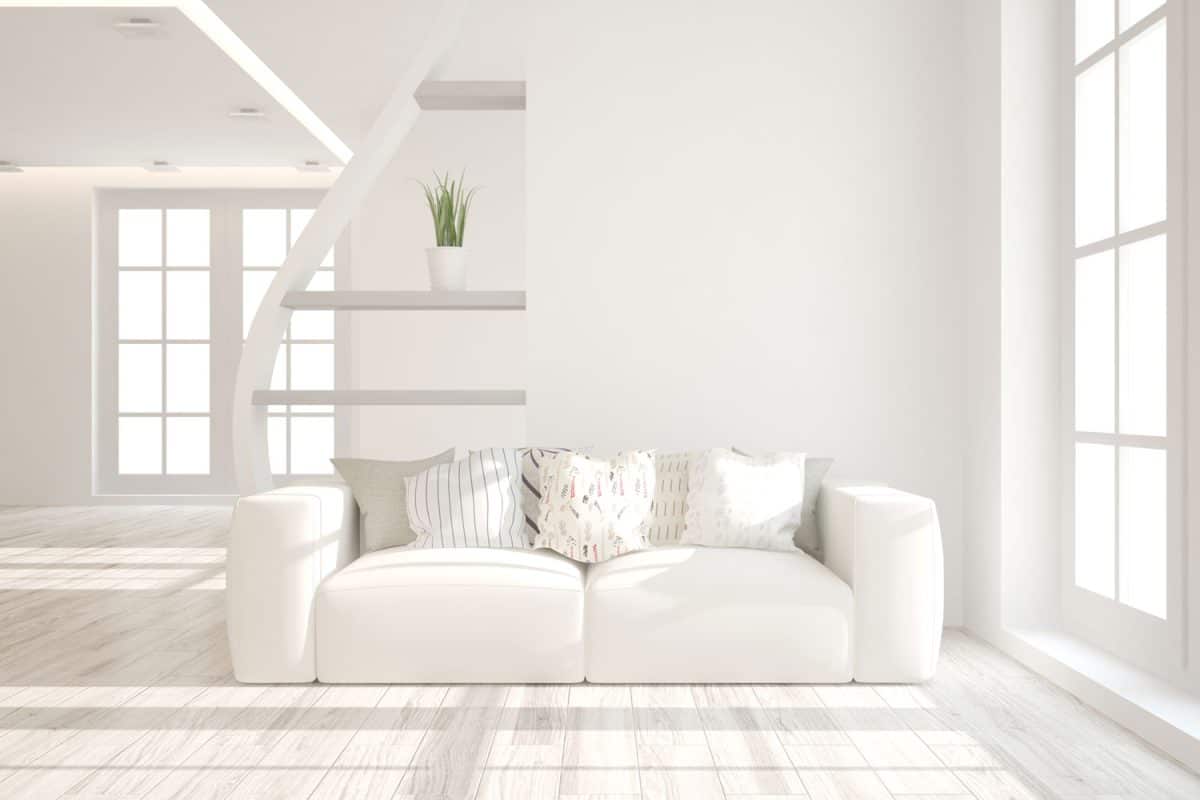 A white inspired living room with a white sofa and white walls