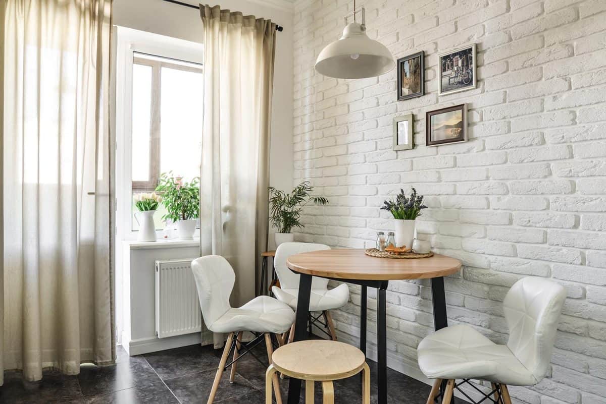 Bouquet of tulips in interior of the kitchen in Scandinavian style with white furniture and a dining table