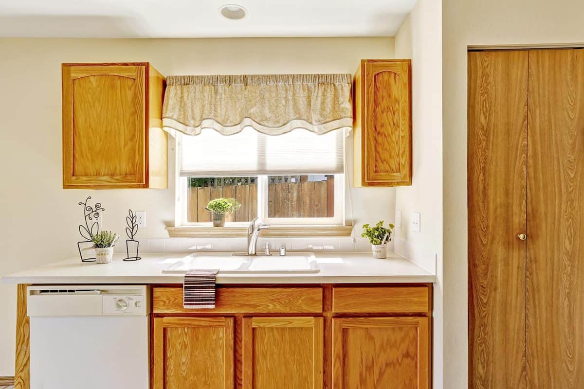Kitchen room with wooden storage cabinets and window view
