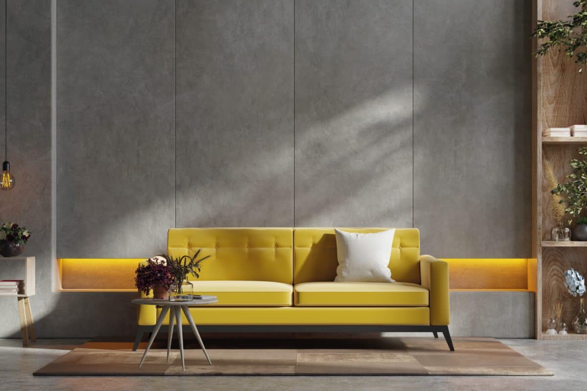 Yellow sofa and a wooden table in living room interior with plant, concrete wall