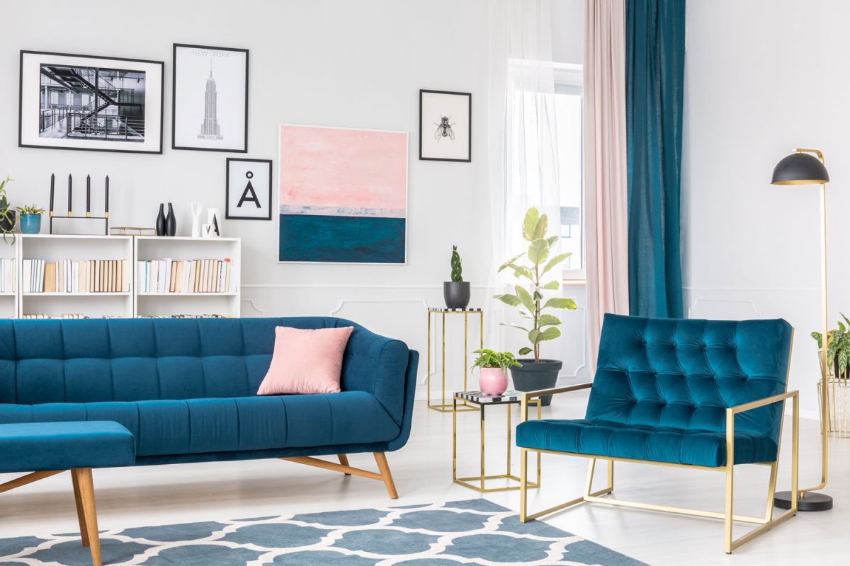 A blue and white themed living room with blue sofas and armchairs matched with pink and blue curtains