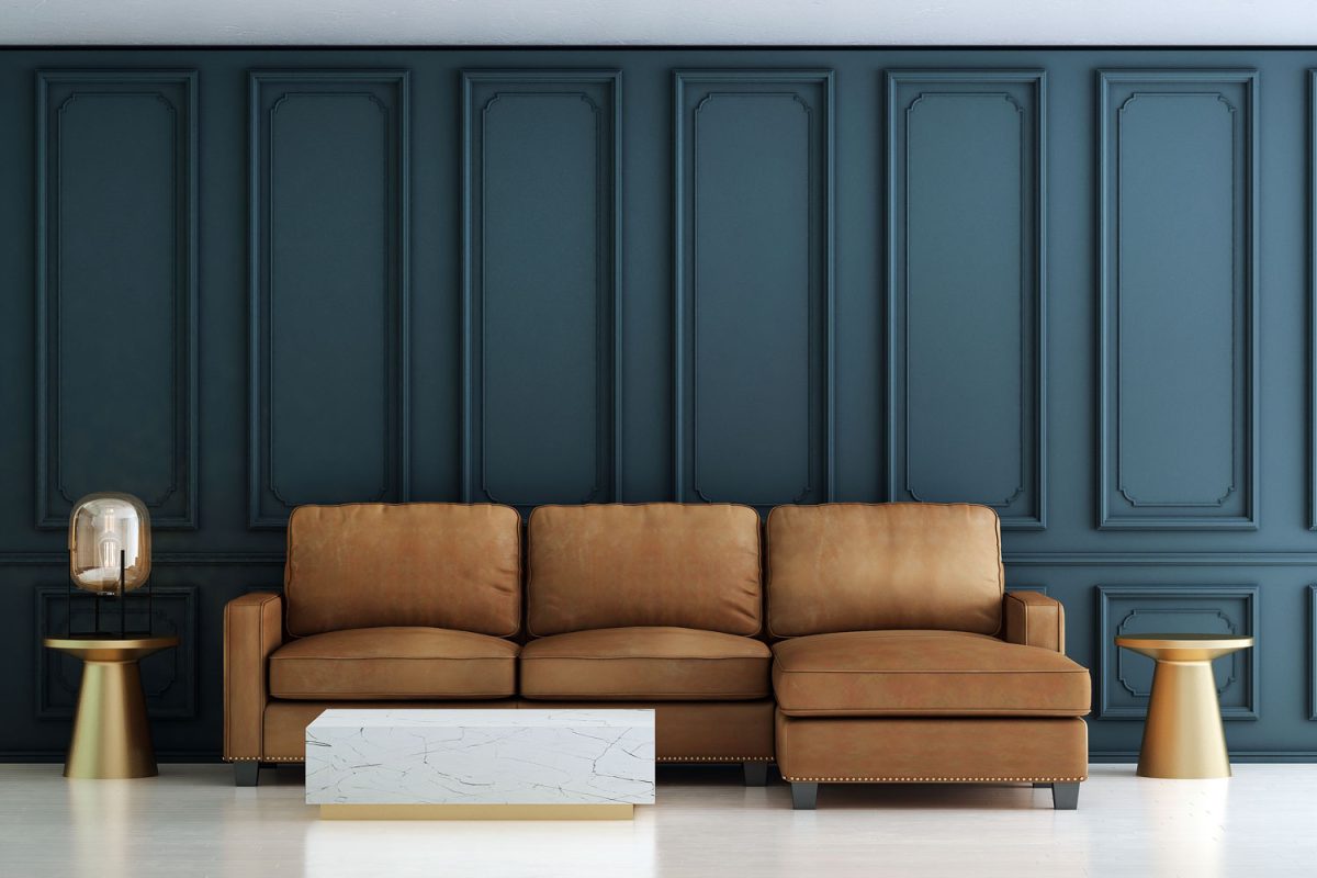 A blue flat paneled wall with a leather sectional sofa