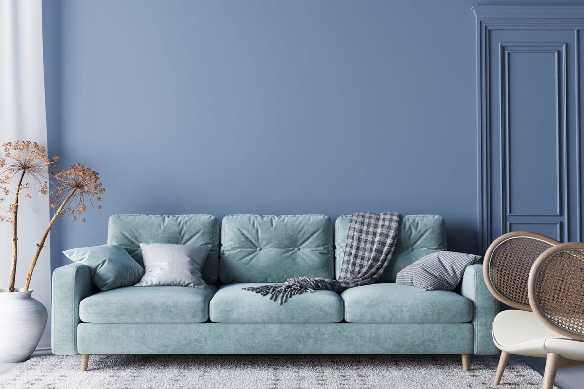 A blue sofa with blue throw pillows and throw in a blue themed living room