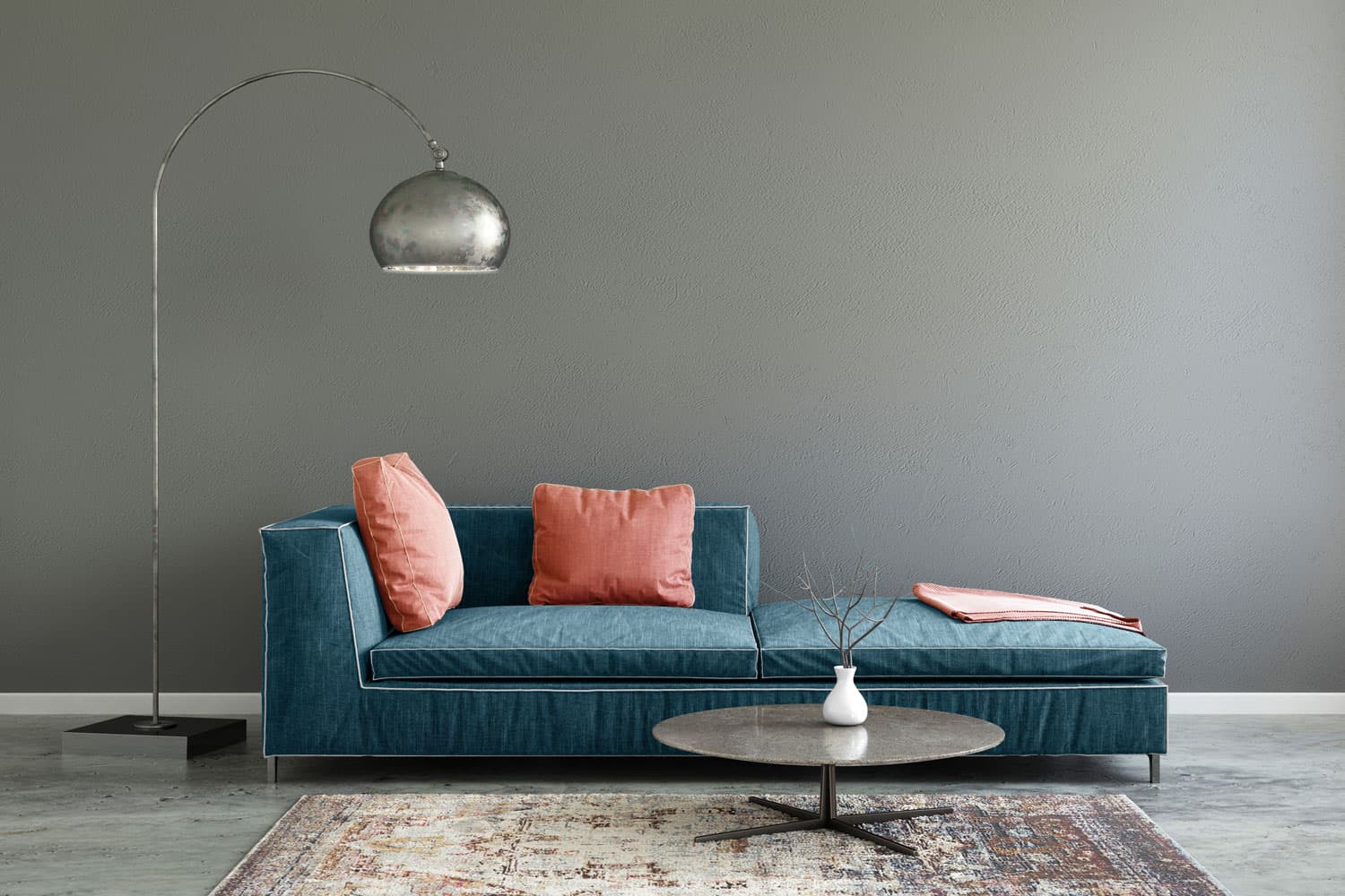 A blue sofa with light pink throw pillows with a dangling lamp on the side in a gray living room, What Color Furniture Goes With Gray Walls And Gray Floors?