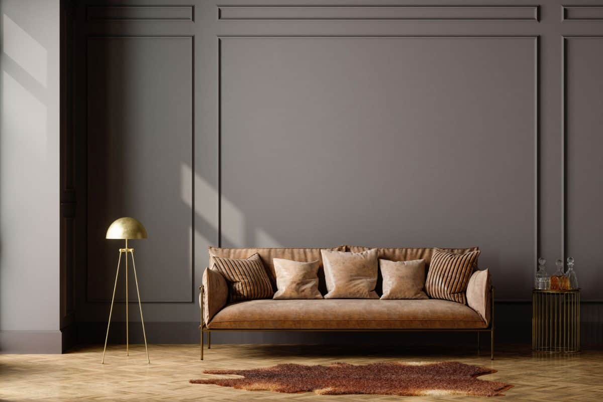 A brown flat panel wall with a brown leather sofa with a brown irregular carpet