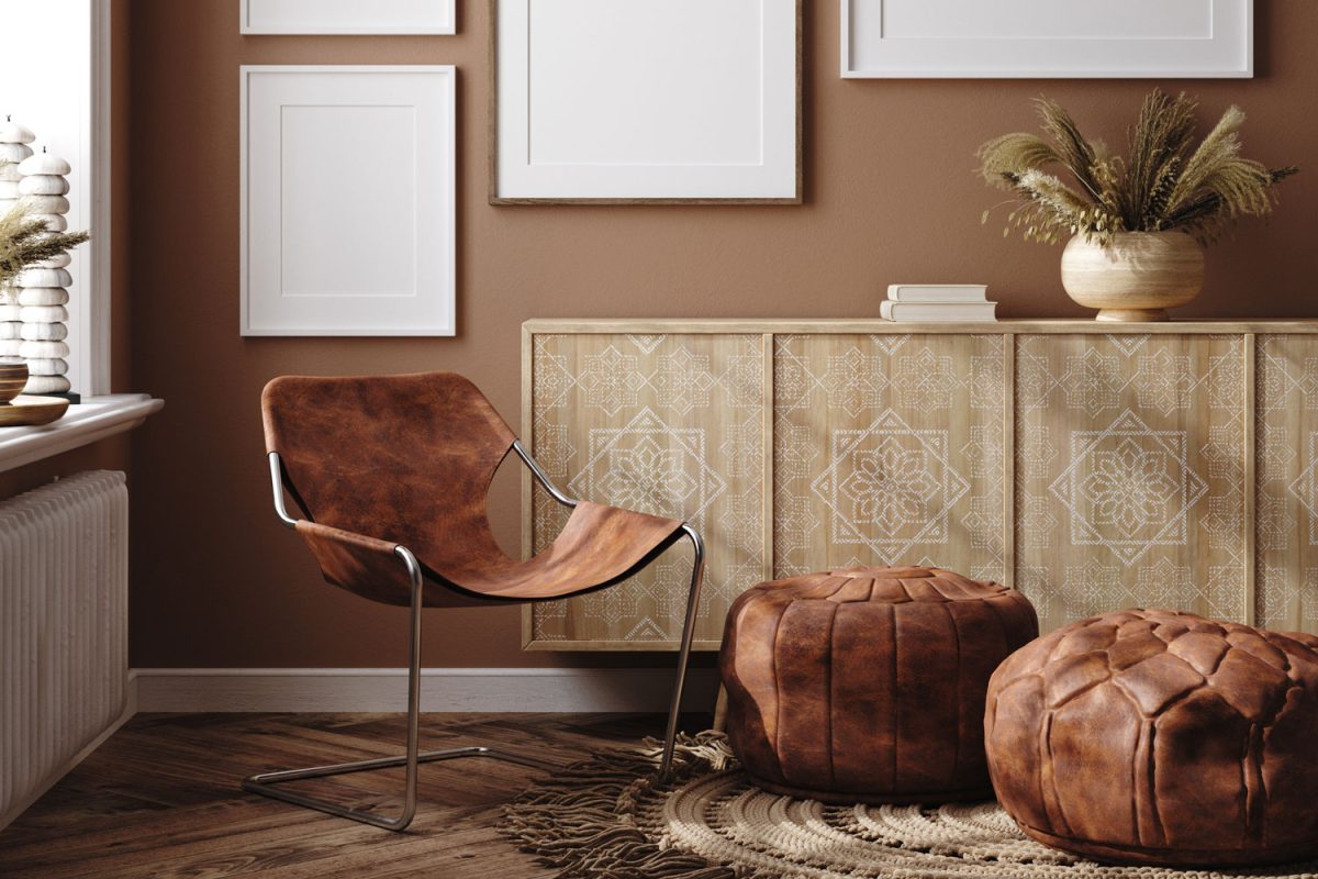A brown inspired living room with brown leather ottoman and empty white canvas