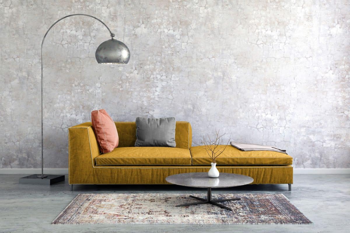 A brownish yellow colored sectional sofa with a dangling lamp