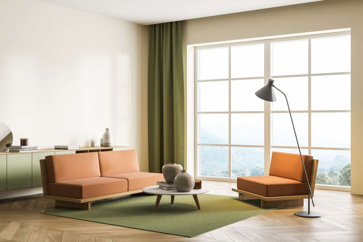 A gorgeous contemporary inspired living room with green carpet and brown sofas