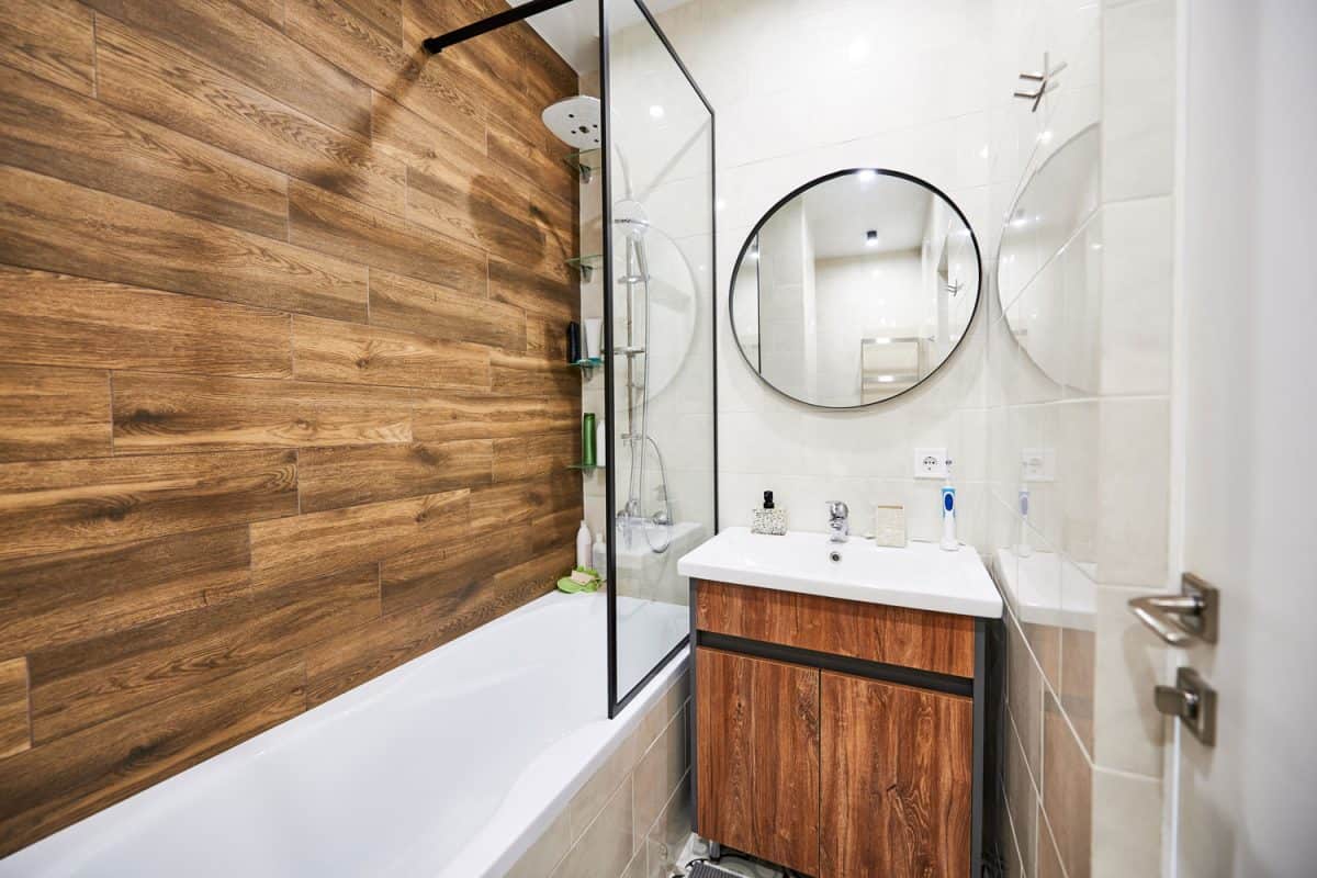 A gorgeous modern bathroom with a wooden decorative wall and white tiled walls