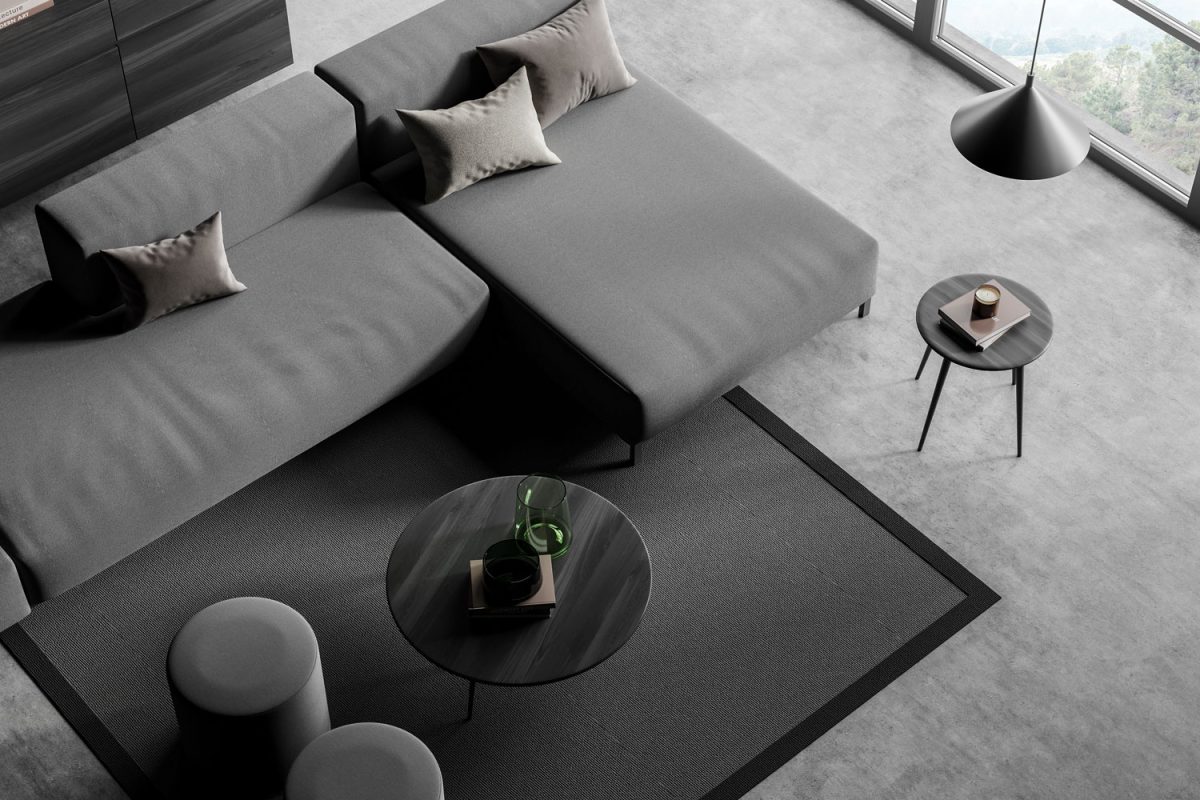 A gray sectional sofa with gray throw pillows, gray ottomans and a gray coffee table to match the gray rug