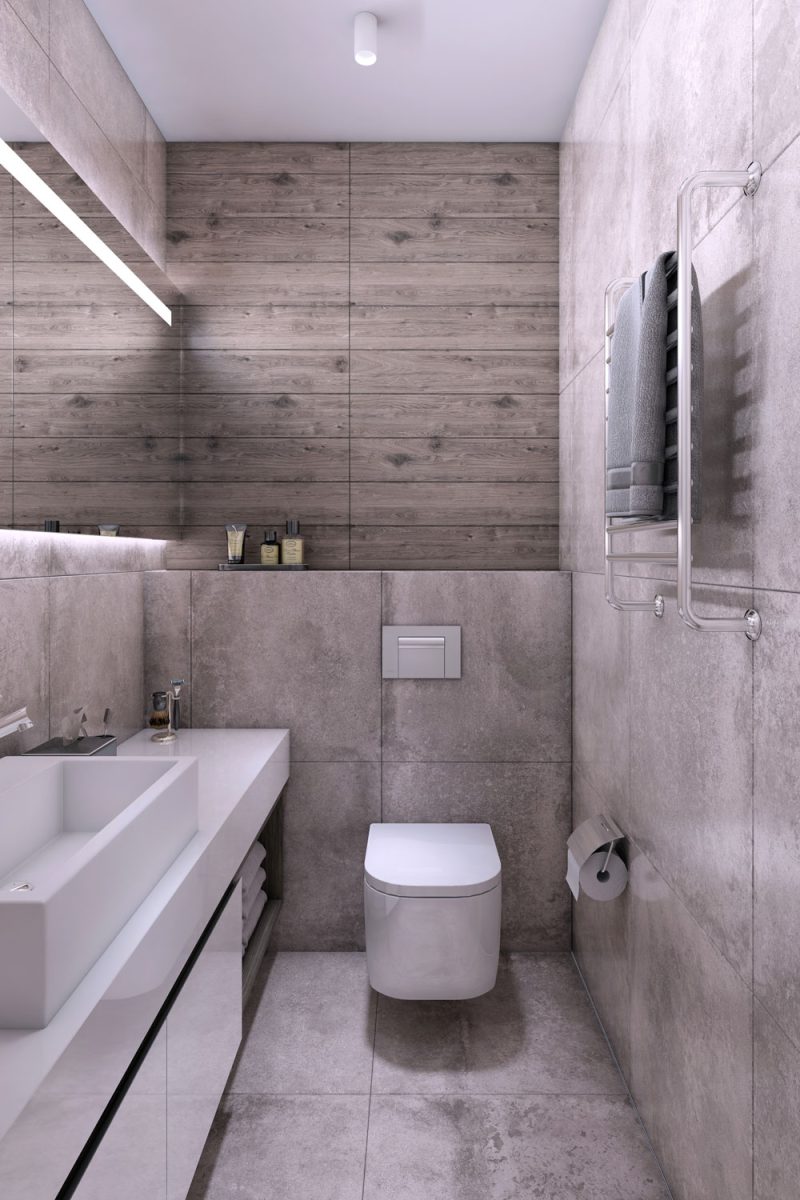 A gray tiled narrow bathroom with a wooden backsplash