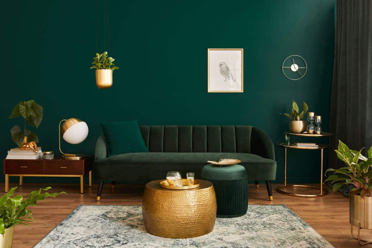 A green accent wall complementing the green sofas and ottoman