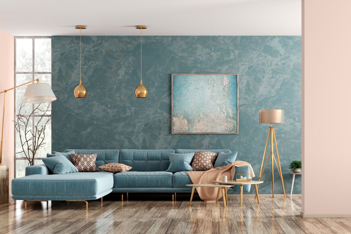 A huge blue texture wall matched with a turquoise colored sectional sofa and hardwood flooring