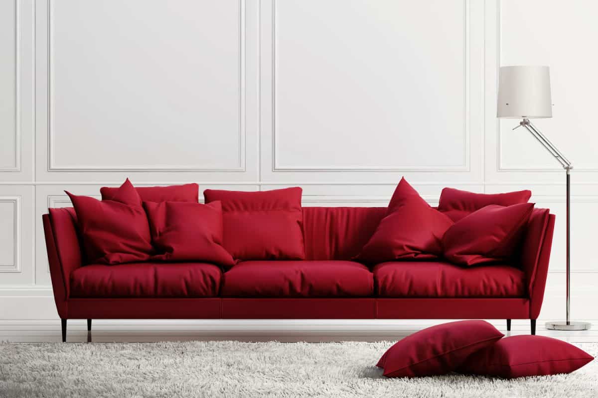 A long red sleeper sofa inside a white living room