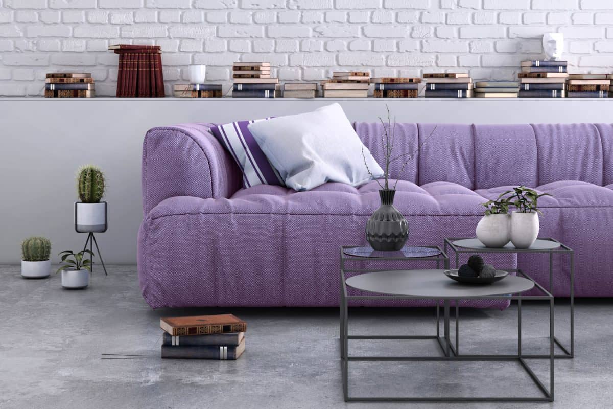 A purple sofa with patterned throw pillows inside a gorgeous living room