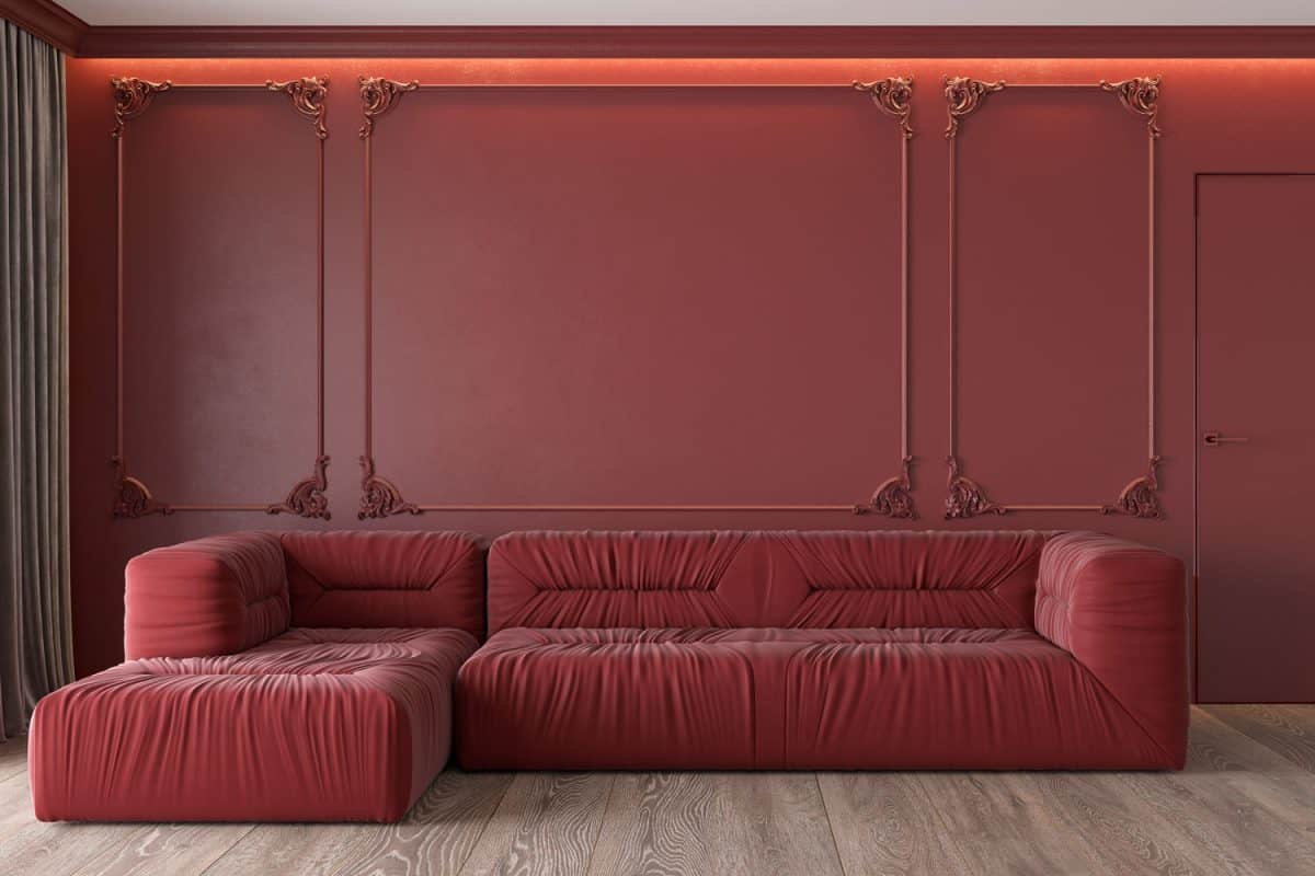 A red leather sectional sofa with red flat paneled walls