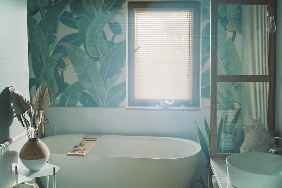 A bathroom with tropical leaves pattern on the wall, 11 Ideas For Bathroom Walls [Alternatives to Paint]