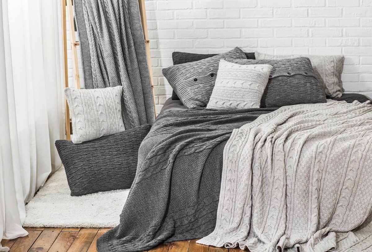 Bedroom in gray white tones knitted plaid pillow bed