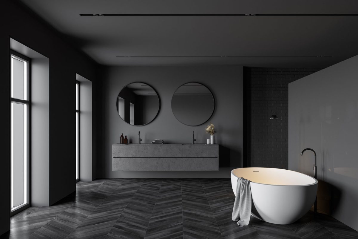 Extremely luxurious modern bathroom with two huge circular mirrors with a black paneled vanity cabinet and a white bathtub