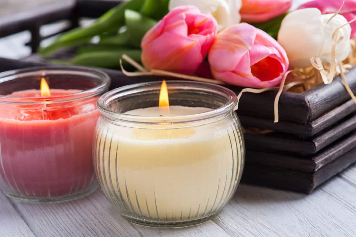 Glass candle jars and pink roses on the small square basket, 7 Popular And Trendy Candle Scents For 2022