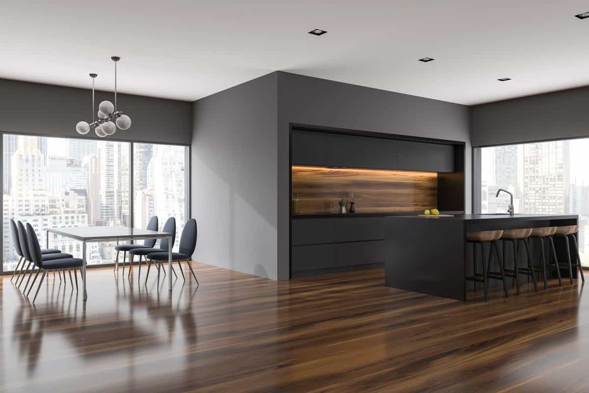 Gray dining room and kitchen corner with panoramic windows, What Color Furniture Goes With Gray Walls And Dark Wood Floors?