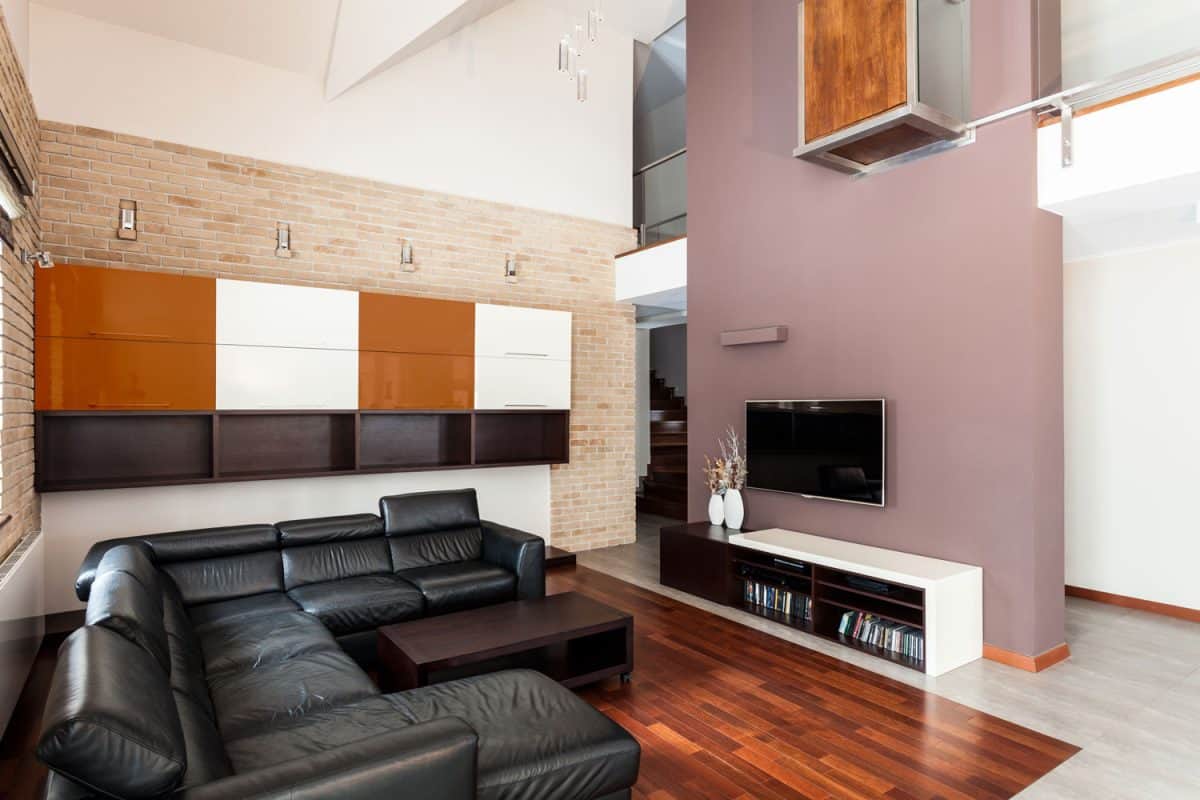 Large penthouse with high ceilings, living room showing black couch