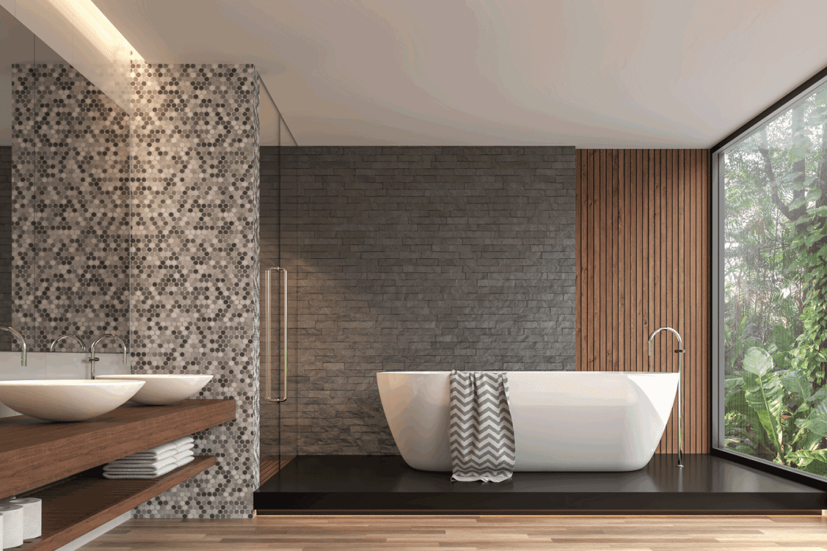Modern contemporary bathroom. There are gray nature stone brick wall, wood floor.