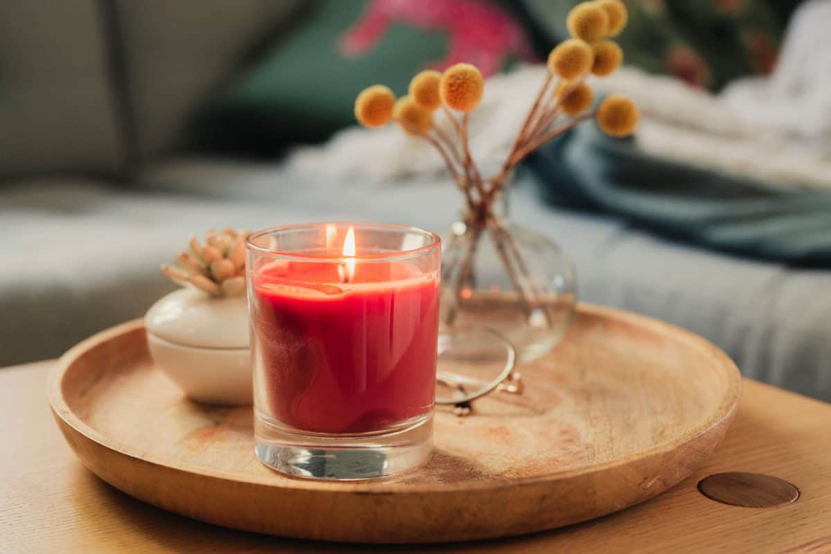 Scented candle burning on sofa table