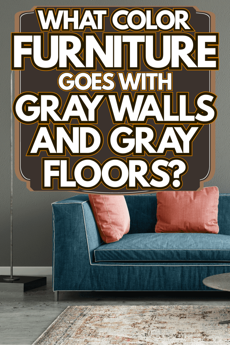 A blue sofa with light pink throw pillows with a dangling lamp on the side in a gray living room, What Color Furniture Goes With Gray Walls And Gray Floors?