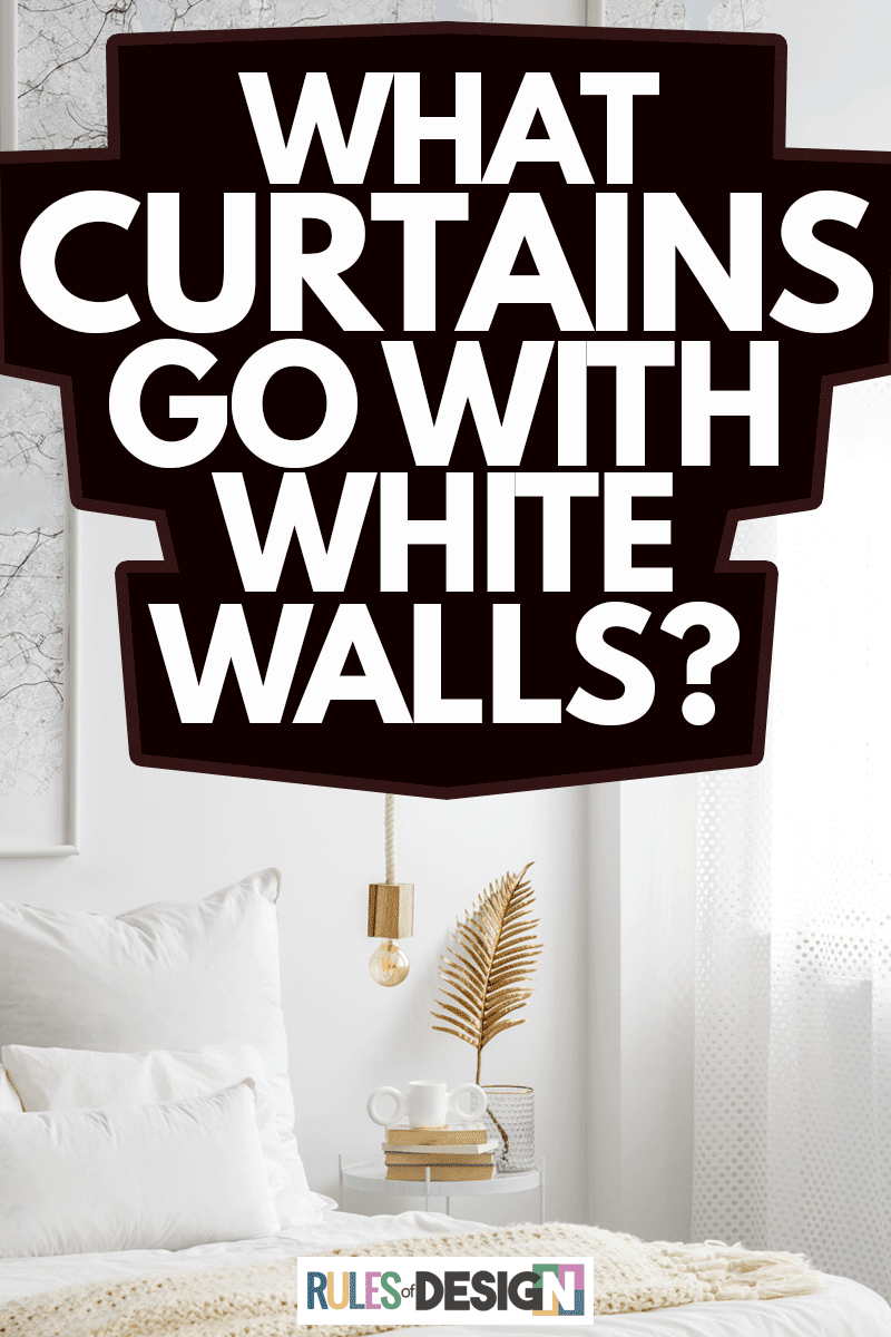 Simple bulb lamp on a rope hanging above bed with white bedclothes, books and gold fern leaf on an end table in white bedroom interior, What Curtains Go With White Walls?
