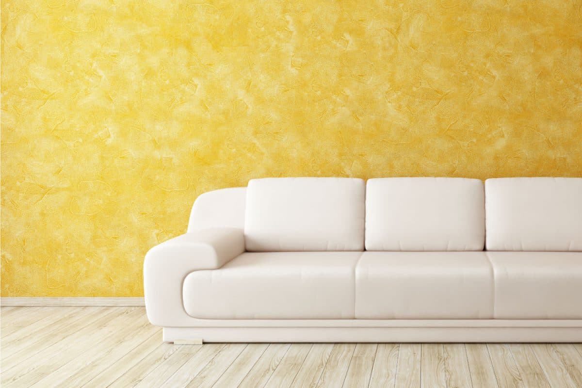 modern beige couch inside a yellow walled living room