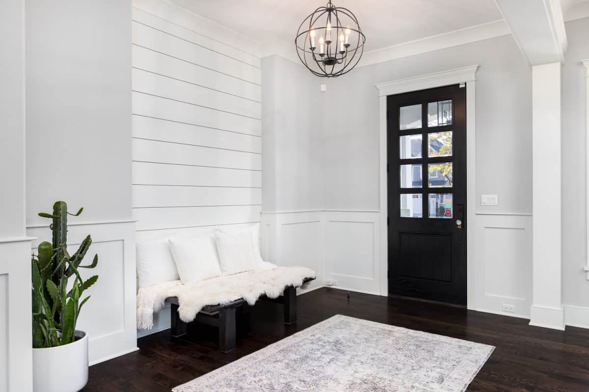 A beautiful foyer entrance with a light hanging above the dark hardwood floors