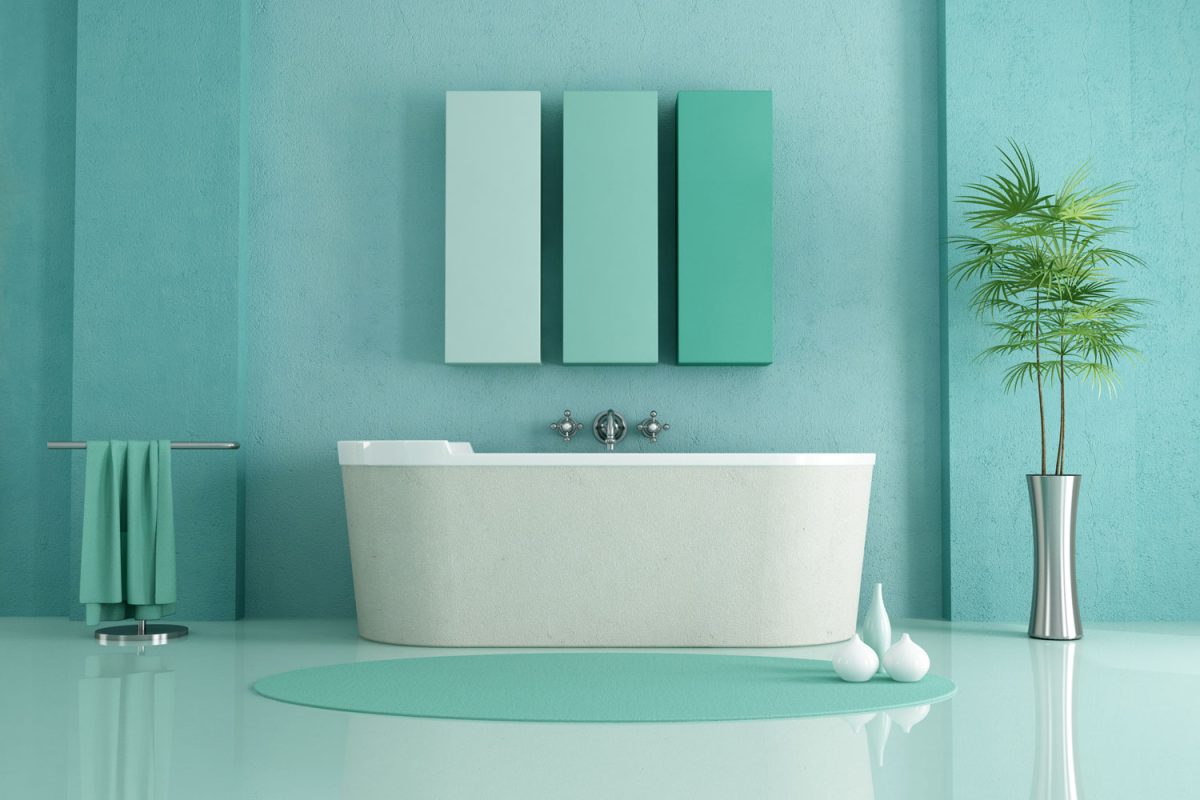 A green themed modern bathroom with a white bathtub and a plant on the side