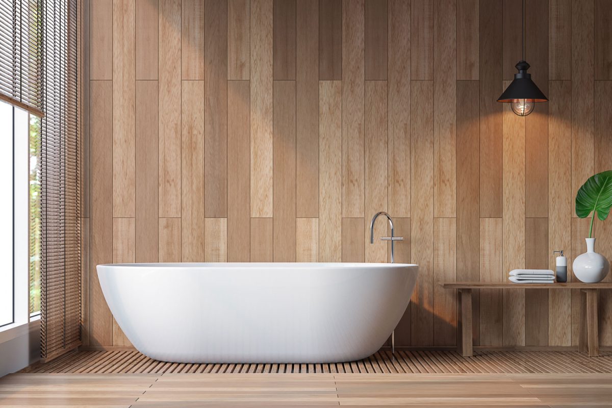 A long white bathtub inside a wooden paneled bathroom wall