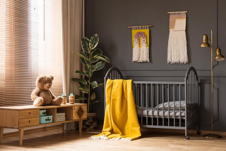 Baby room interior with a yellow blanket standing between a low cupboard with a bear and a lamp, What Curtains Go With Gray Walls?