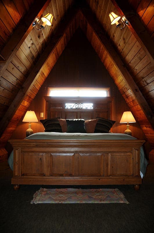 Bedroom in loft of wooden cabin