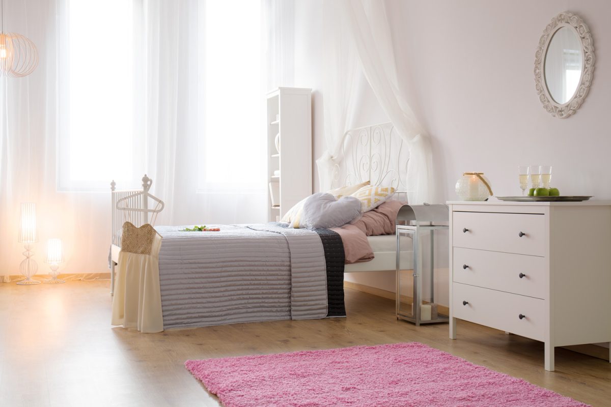 Bedroom with single bed, pink carpet and white dresser

