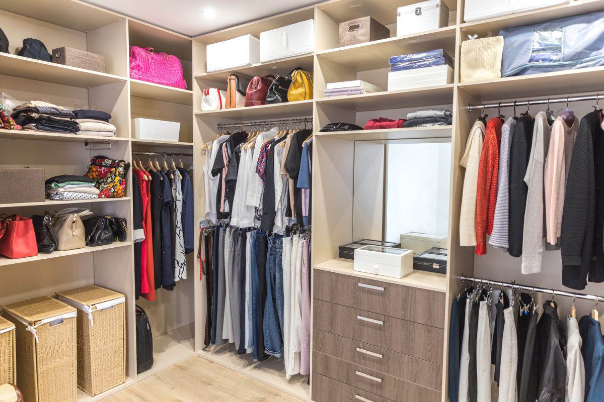 Big wardrobe with different clothes for dressing room. Walk in closet

