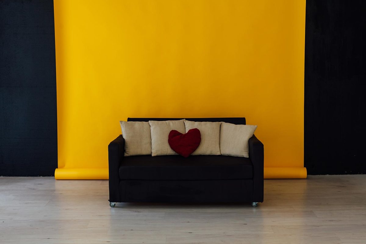 Black office sofa in the interior of the yellow room