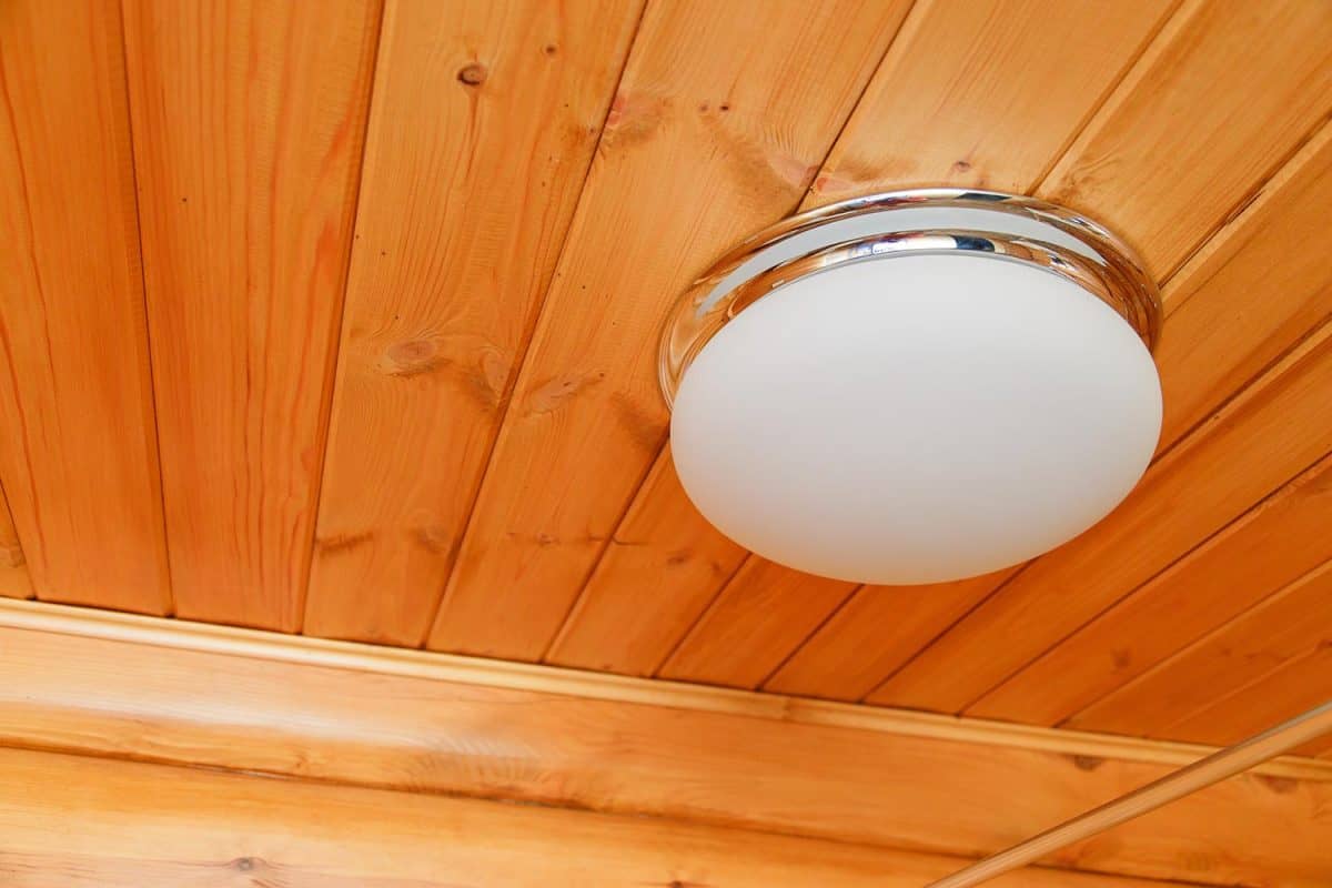 Ceiling glass white lamp on a wooden ceiling