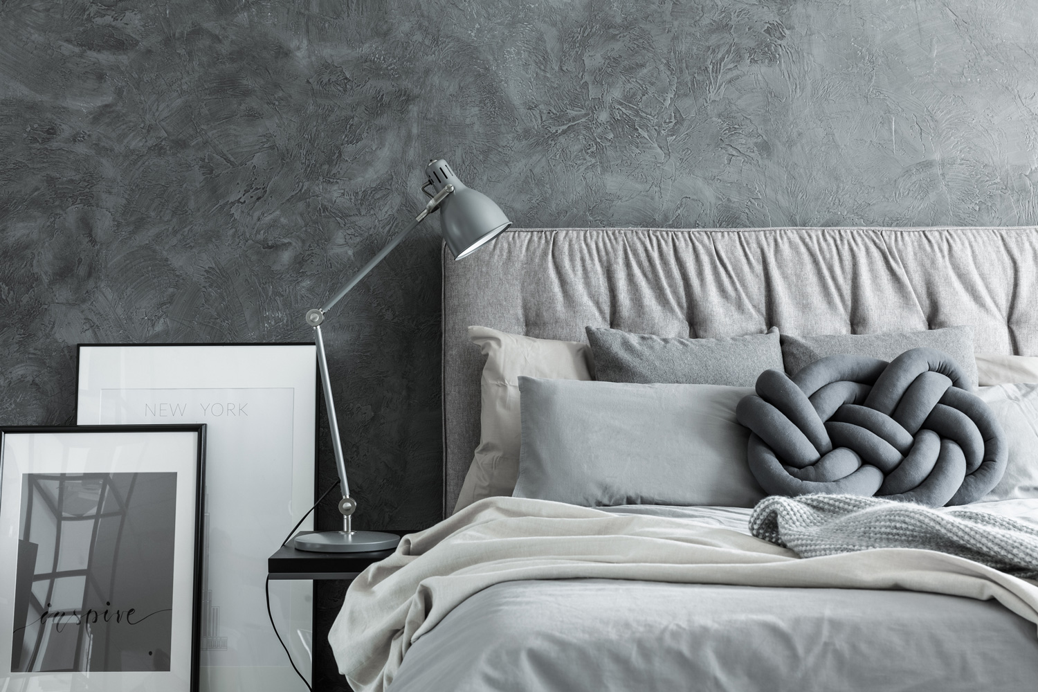 Close-up, side view of cozy modern bedroom with gray headboard