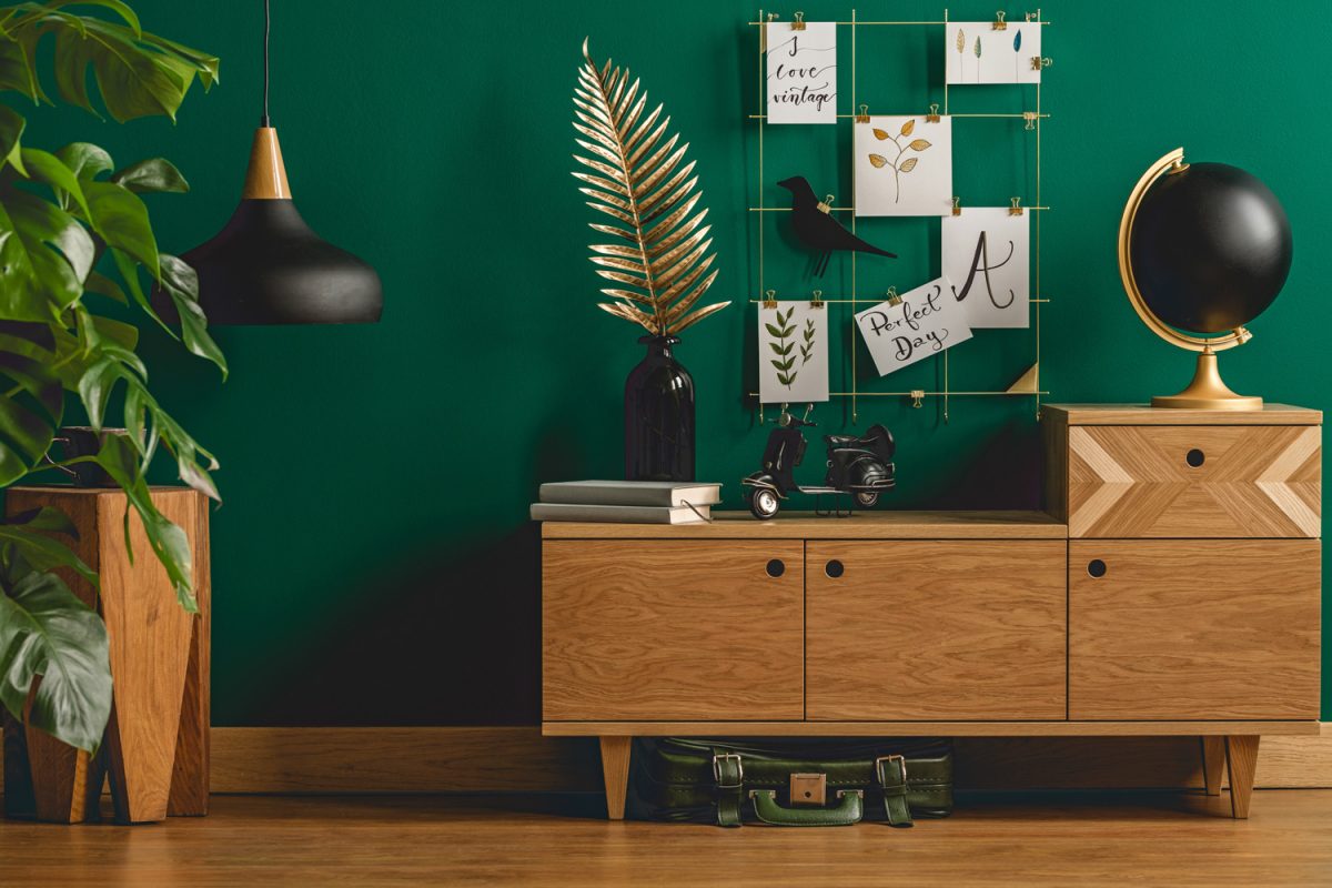 Dark green apartment interior with scandinavian style wooden furniture and designer black and gold decorations