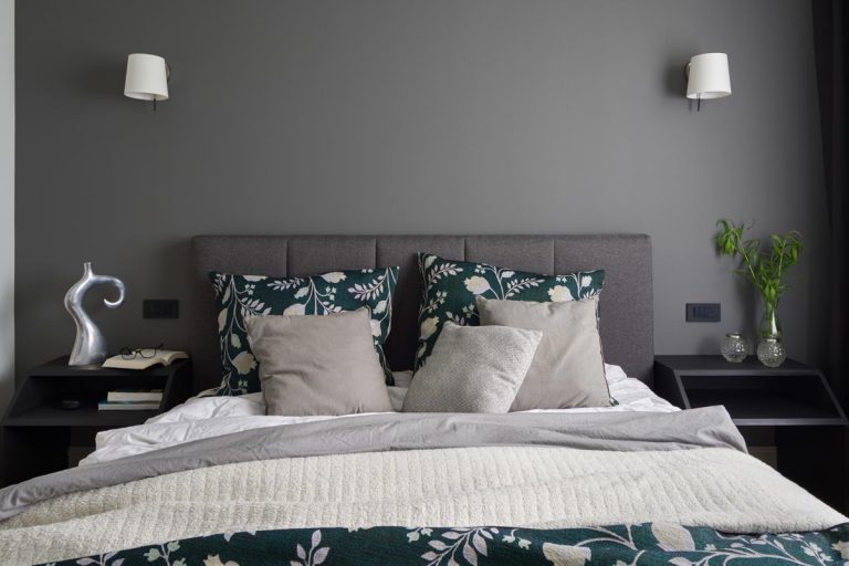 An elegant bedroom with gray headboard and modern bedside table with decorations, What Color Bedding Goes With A Gray Headboard?