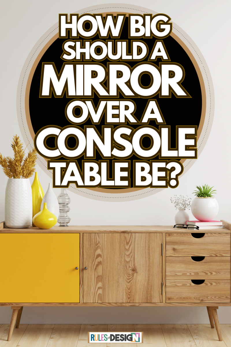 A small wooden console decorated with vases and a withered whey plant on white vases, How Big Should A Mirror Over A Console Table Be?
