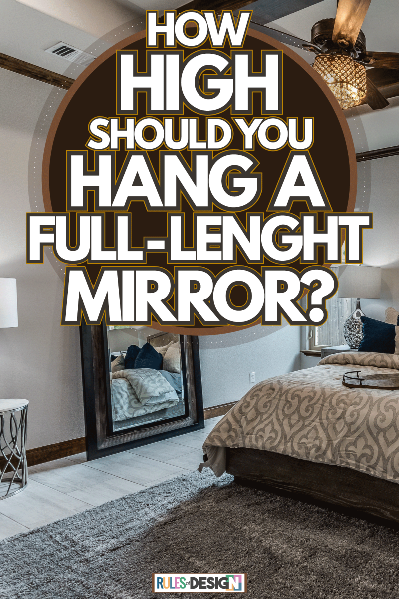 A bedroom evenly spaced out with gorgeous beddings with huge windows on the side and a full length mirror on the side, How High Should You Hang A Full-Length Mirror?