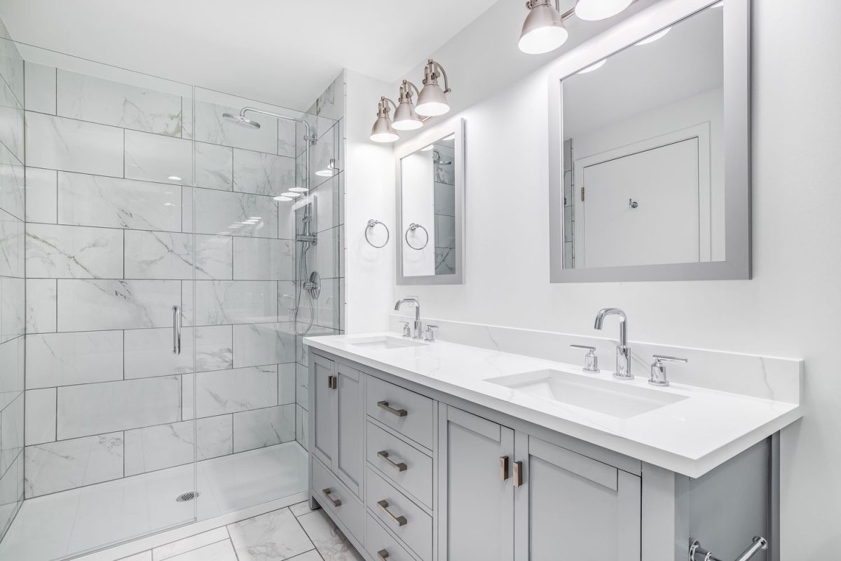 Interior of a white and gorgeous bathroom matched with a white countertop and light gray cabinets