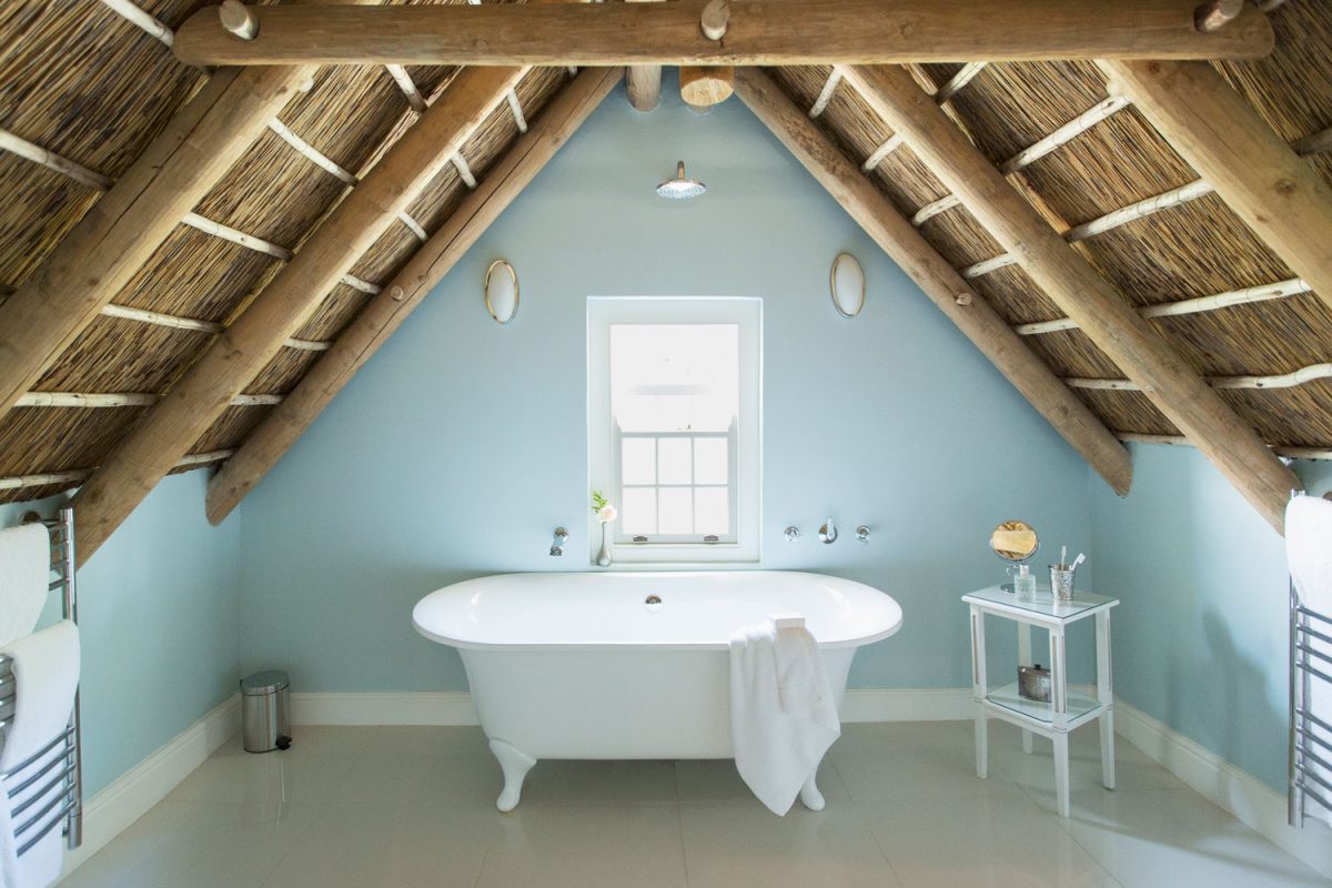Interior of sloped ceiling bathroom with the roof constructed from wooden and cogongrass