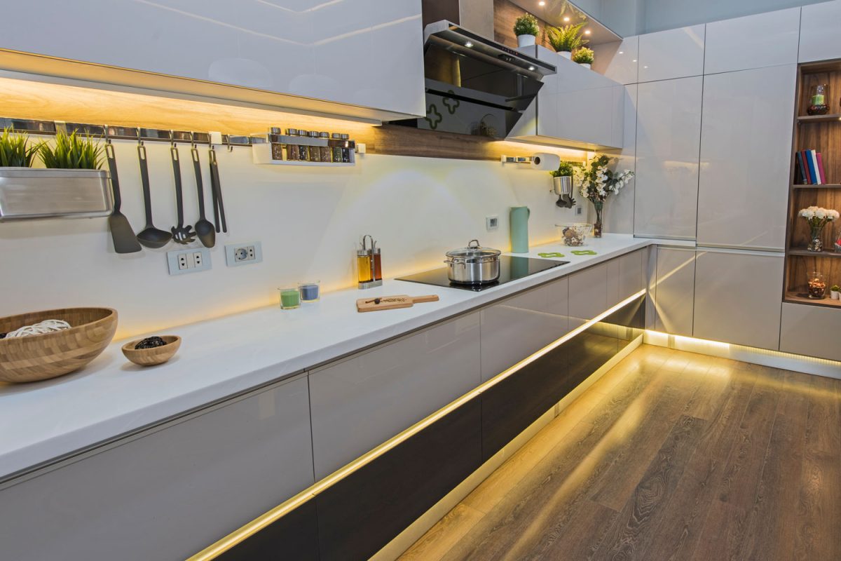 Long gorgeous kitchen with backlight below the cabinets mathced with laminated flooring