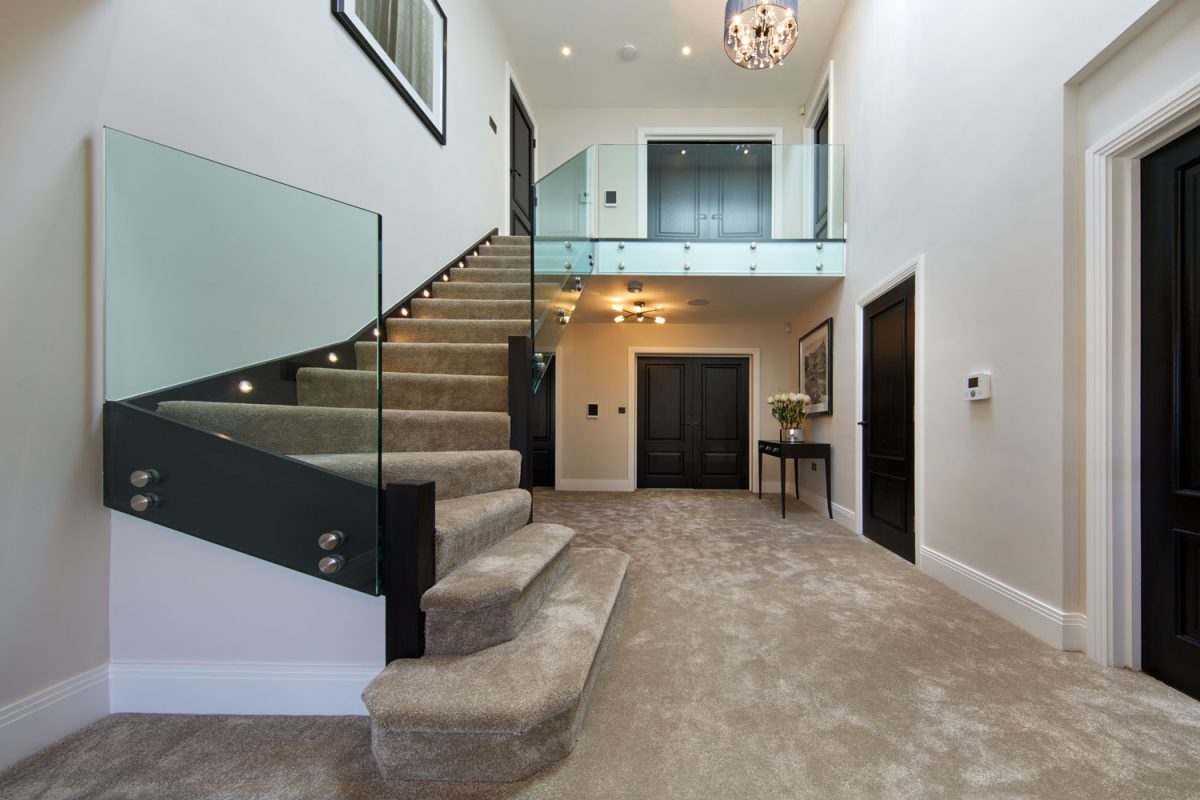Luxury new home with modern glass staircase and first floor landing