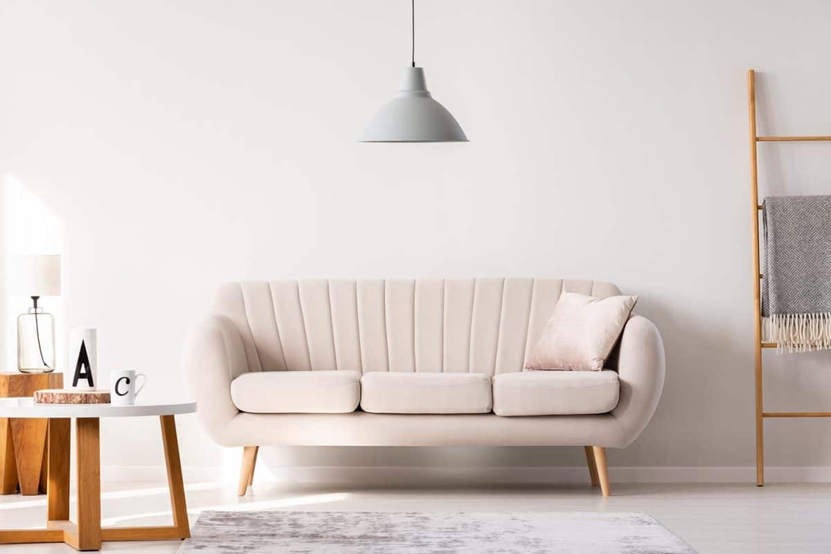 Real photo of a beige sofa standing in a simple living room